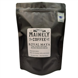 A black bag of coffee with a label saying, "Royal Maya - Fair Trade Organic Water Process Decaf"