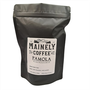 Black bag of coffee with a label saying, "Pamola - Water Process Decaf"