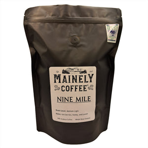 Black bag of coffee with a label saying, "Nine Mile" with a Maine Made sticker
